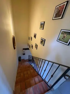 a living room with a staircase and a couch at Maison de campagne, deux chambres, vue sur les montagnes in Sartène