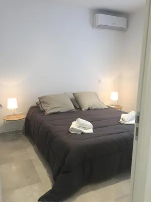 a bedroom with a large bed with two lamps at Villa Filippi in Porto-Vecchio