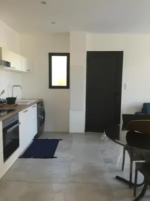a kitchen with a table and a black door at Villa Filippi in Porto-Vecchio