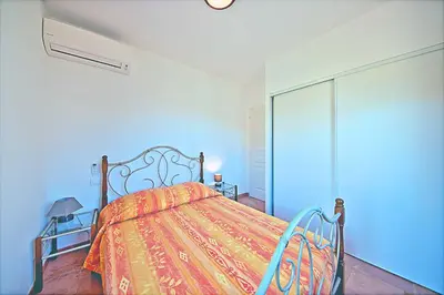a bedroom with a bed with a colorful blanket at Orasi, Sartene, gîte dans villa climatisée tout confort in Sartène
