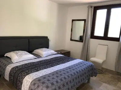 a bedroom with a bed and a mirror and a window at CHAMBRES DHOTES CORSE in Venaco