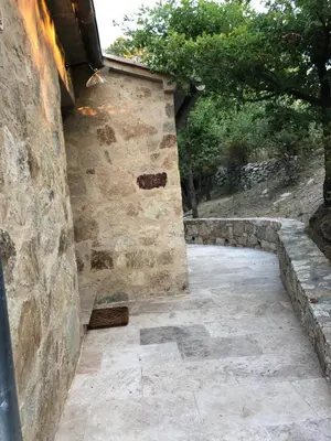 a stone wall next to a stone walkway at CHAMBRES DHOTES CORSE in Venaco