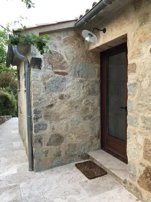 a stone house with a door and a lamp at CHAMBRES DHOTES CORSE in Venaco