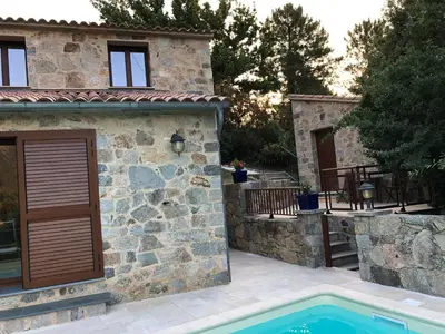 a stone house with a swimming pool in front of it at CHAMBRES DHOTES CORSE in Venaco