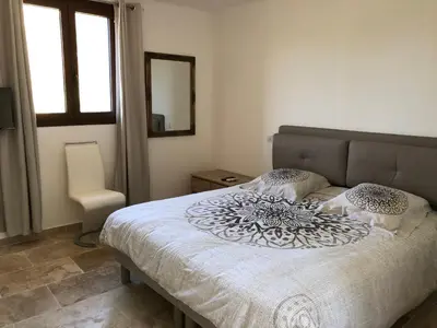 a bedroom with a bed and a mirror and a window at CHAMBRES DHOTES CORSE in Venaco