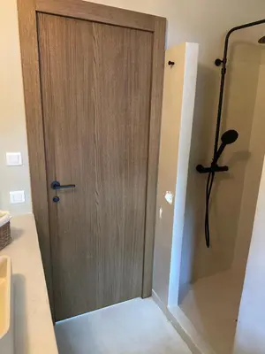 a wooden door in a bathroom with a shower at Villa Valrossa in Porto-Vecchio