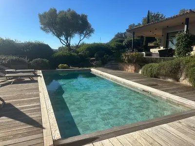 a swimming pool on a deck next to a house at Villa Valrossa in Porto-Vecchio