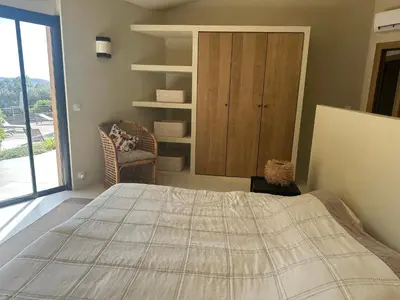 a bedroom with a bed and a cabinet and a window at Villa Valrossa in Porto-Vecchio