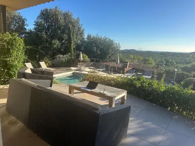 a patio with a table and chairs and a pool at Villa Valrossa in Porto-Vecchio