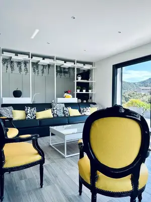 a living room with a blue couch and yellow chairs at A GIOIA DI CAMPA in Figari