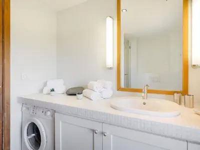 a bathroom with a sink and a washing machine at Apartment La Porte Génoise by Interhome in Porto-Vecchio