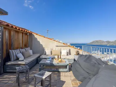 a patio with a couch and tables on a balcony at Apartment La Porte Génoise by Interhome in Porto-Vecchio