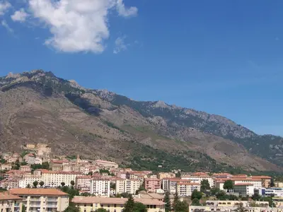 a city in front of a mountain with buildings at Vanina Park in Corte