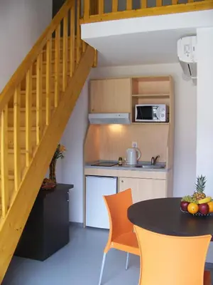 a kitchen with a table and a kitchen under a staircase at Vanina Park in Corte