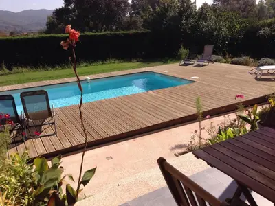 a pool with a wooden deck and a table and chairs at I Casilari in Serra-di-Ferro