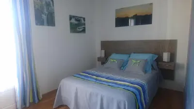 a bedroom with a bed with blue pillows at Joli villa Marcel classée 3 étoiles in Calenzana