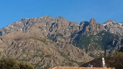 a mountain range with a building in front of it at Joli villa Marcel classée 3 étoiles in Calenzana