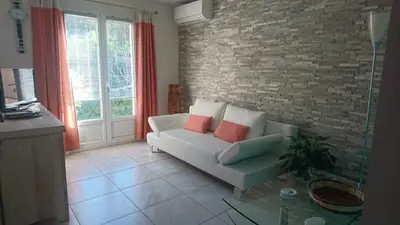a living room with a couch and a brick wall at Joli villa Marcel classée 3 étoiles in Calenzana
