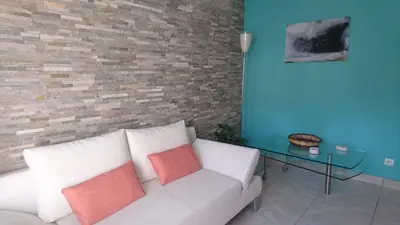 a living room with a white couch and a glass table at Joli villa Marcel classée 3 étoiles in Calenzana