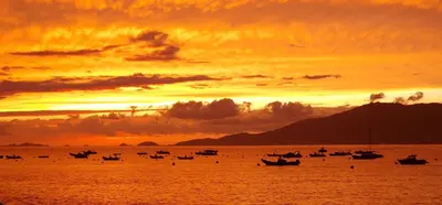 a group of boats in the water at sunset at Hôtel U Paradisu in Porticcio