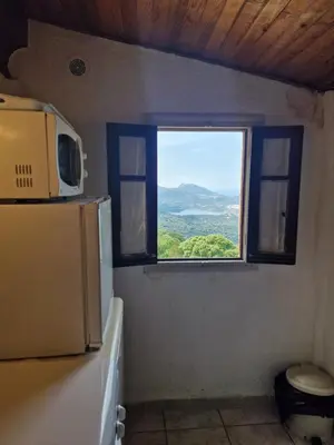 a bathroom with a blue toilet in a room at Vacancorse Maison U Canale in Speloncato