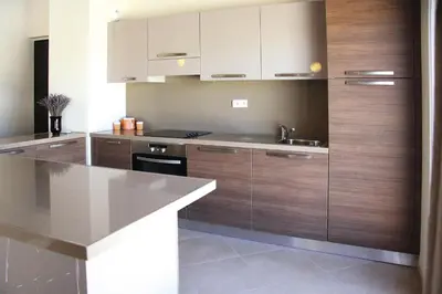 a kitchen with wooden cabinets and a counter top at Apartment in Corsica near Palombaggia Beach in Porto-Vecchio