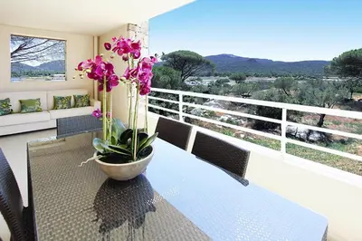 a table with a potted plant on a balcony at Apartment in Corsica near Palombaggia Beach in Porto-Vecchio