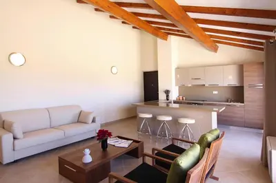 a living room with a couch and a table and a kitchen at Residence Salina Bay, Porto Vecchio, Apartment garden side in Porto-Vecchio