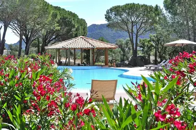 a swimming pool with a gazebo and some flowers at Residence Salina Bay, Porto Vecchio, Apartment garden side in Porto-Vecchio