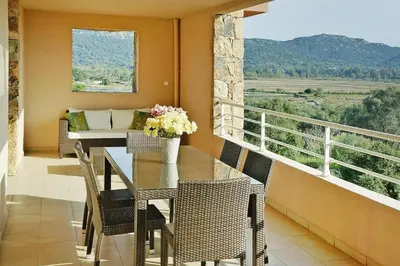 a balcony with a table and chairs and a couch at Residence Salina Bay, Porto Vecchio, Apartment garden side in Porto-Vecchio