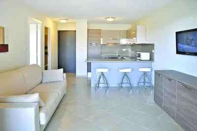 a living room with a couch and a kitchen at Apartment in Corsica near Palombaggia Beach in Porto-Vecchio