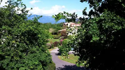 a view of a garden with a house in the distance at Residence de Tourisme Marina Corsa in Ghisonaccia