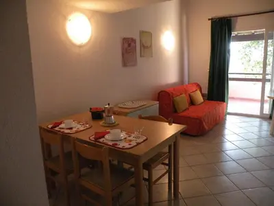 a living room with a table and a chair at Residence de Tourisme Marina Corsa in Ghisonaccia