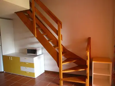 a staircase in a room with a desk and a microwave at Residence de Tourisme Marina Corsa in Ghisonaccia