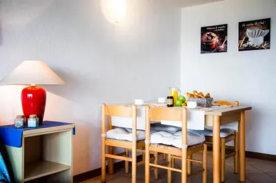 a small table with chairs and a table with a lamp at Residence de Tourisme Marina Corsa in Ghisonaccia