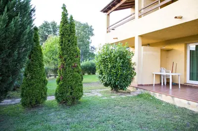 a group of trees in front of a house at Residence de Tourisme Marina Corsa in Ghisonaccia