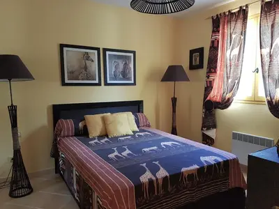a bedroom with a bed with a blue blanket on it at Residence U MELU GRAND T3 JAUNE à l'étage in Tiuccia