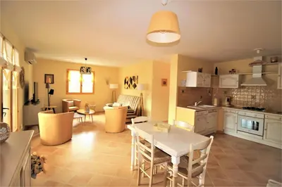 a kitchen and living room with a table and chairs at Residence U MELU GRAND T3 JAUNE à l'étage in Tiuccia