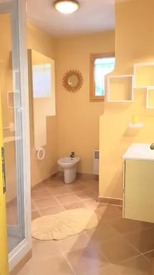 a bathroom with a toilet and a glass shower at Residence U MELU GRAND T3 JAUNE à l'étage in Tiuccia