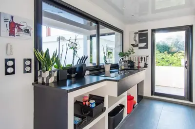 a kitchen with a counter with plants and a window at Maison 