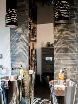 a bathroom with two silver sinks and a brick wall at Maison 