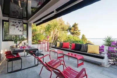a patio with a couch and red chairs at Maison 