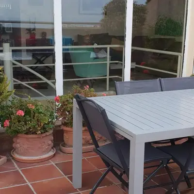 a white table and chairs on a porch with plants at dupleix U Forcone in Ajaccio