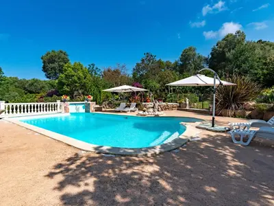 a swimming pool with chairs and an umbrella at Holiday Home Campestra by Interhome in Coti-Chiavari