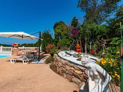 a stone wall with a statue next to a swimming pool at Holiday Home Campestra by Interhome in Coti-Chiavari