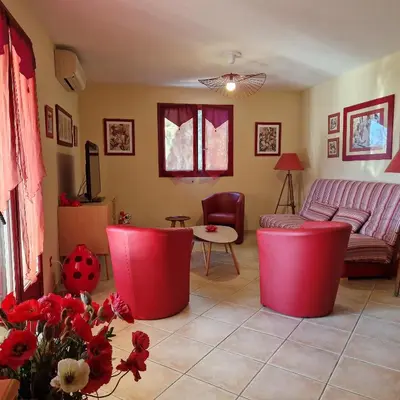 a living room with a couch and a table at Résidence U MELU GRAND T3 ROUGE en rez de jardin in Tiuccia