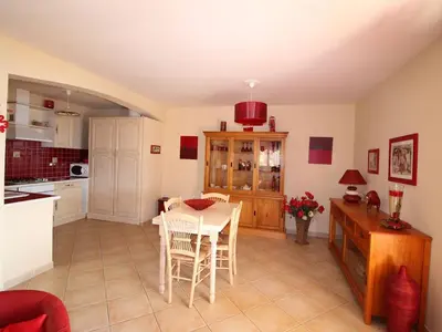 a kitchen and dining room with a table and chairs at Résidence U MELU GRAND T3 ROUGE en rez de jardin in Tiuccia