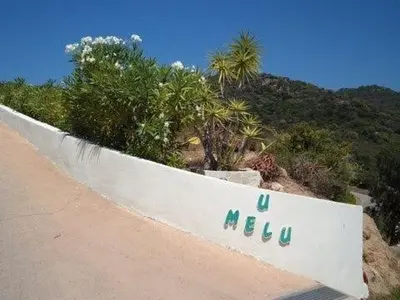 a sign on the side of a dirt road at Résidence U MELU GRAND T3 ROUGE en rez de jardin in Tiuccia