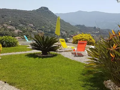 a group of lawn chairs sitting on the grass at Résidence U MELU Grand T2 BLEU en rez de jardin in Tiuccia