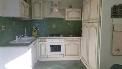 a kitchen with white cabinets and a sink at Résidence U MELU Grand T2 VERT à l'étage in Tiuccia